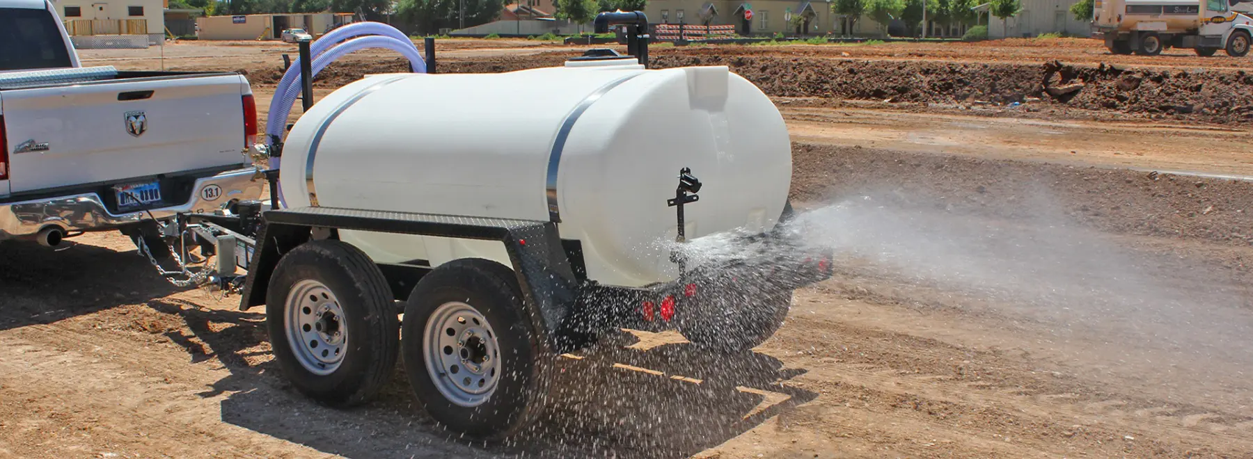 Rear spray bar on water trailer for silica dust control on construction site