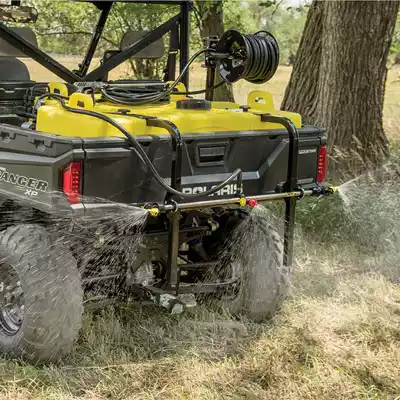 Polaris UTV with a UTV tank sprayer in the back hold spraying off both sides.