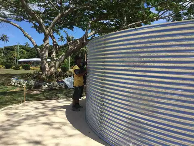 Man checking a corrugated steel tank