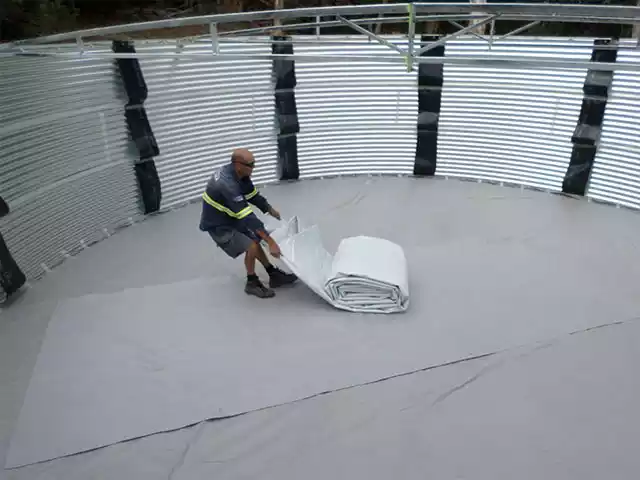 Man installing a liner in a corrugated tank