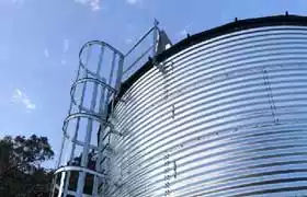 Side view of a corrugated steel tank with a ladder
