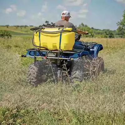 Yellow poly skid sprayer on the back of a four-wheeler.