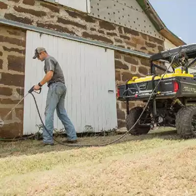 Man using the skid sprayer to spray his yard